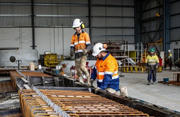 Steel fixers working on rebar formwork in the SRB workshop